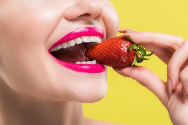 sarı izole lezzetli çilek yiyen mutlu kadın kırpılmış görünümü 