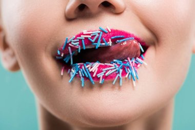 mavi üzerine izole mavi sprinkles ile dudakya dudaklar yalama genç kadın kırpılmış görünümü  