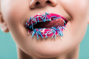 cropped view of young woman licking lips with blue sprinkles isolated on blue   clipart