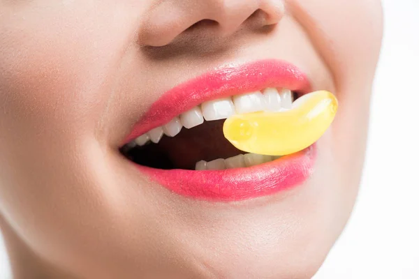 白に隔離された黄色いゼリーキャンディを食べる笑顔の女の子のトリミングビュー — ストック写真