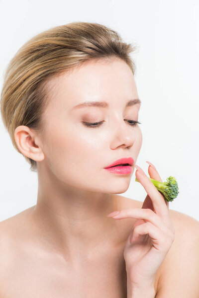 beautiful naked woman holding green ripe broccoli isolated on white  