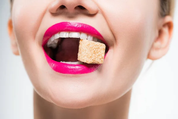 白に砂糖キューブを食べる幸せな女性のトリミングされたビュー — ストック写真