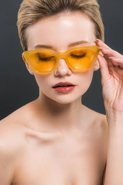 Krásná Mladá Žena Dotýkala Žlutých Slunečních Brýlí Izolovaných Černém — Stock fotografie