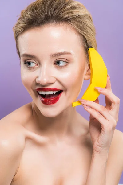 Feliz Jovem Segurando Amarelo Decorativo Banana Perto Orelha Isolada Roxo — Fotografia de Stock