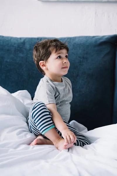 Niedliche Kind Sitzt Auf Dem Bett Mit Weißer Bettwäsche Hause — Stockfoto