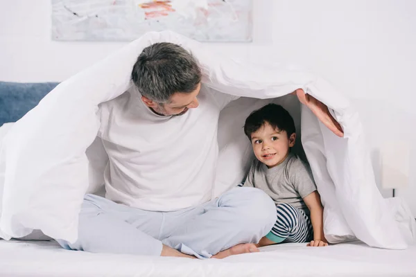 Father Looking Cute Toddler Son While Holding Blanket Sitting Bed — Stock Photo, Image