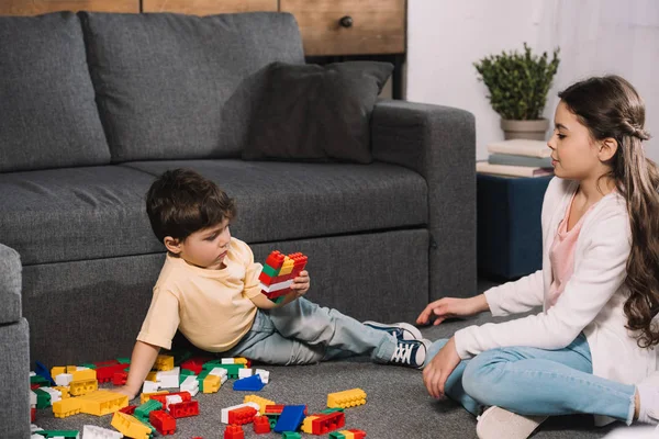 Entzückendes Kind Schaut Kleinkind Bruder Beim Spielen Mit Bunten Spielzeugklötzen — Stockfoto