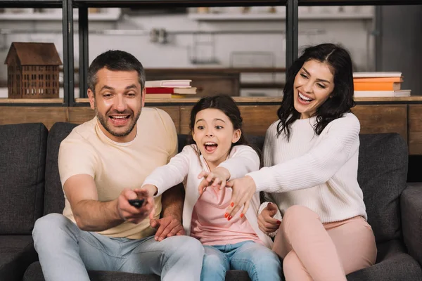 Feliz Hombre Sosteniendo Mando Distancia Cerca Hija Esposa Casa —  Fotos de Stock