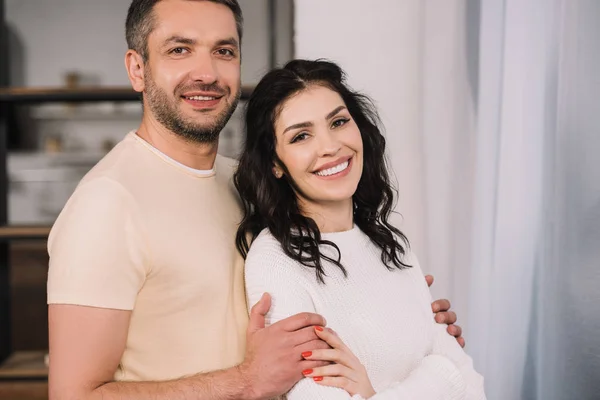 Happy Man Hugging Cheerful Wife While Looking Camera — Stock Photo, Image