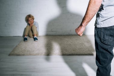 baba ve korkmuş oğlu halı üzerinde oturan kısmi görünümü