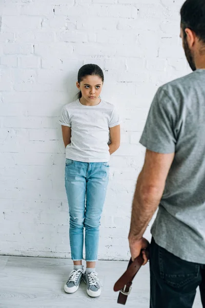 裁剪视图的父亲举行皮带和女儿有冲突 — 图库照片