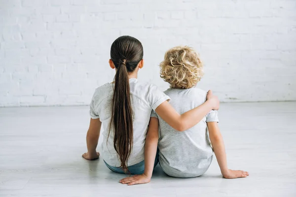 Achteraanzicht Van Twee Kinderen Omarmen Vloer Thuis — Stockfoto