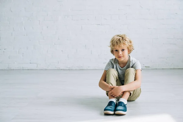 Cute Little Boy Siedzi Podłodze Delikatnie Uśmiech Patrząc Kamerę — Zdjęcie stockowe