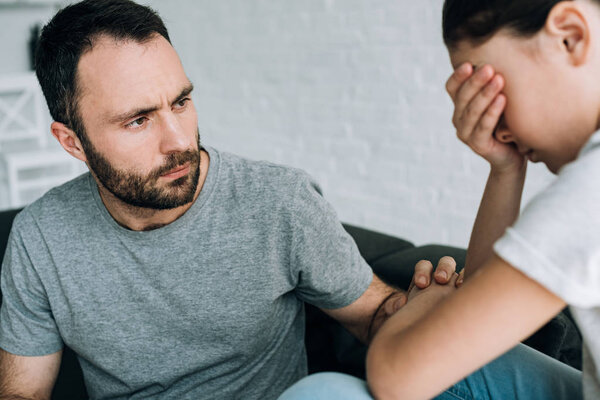 sad daughter and father having conflict at home