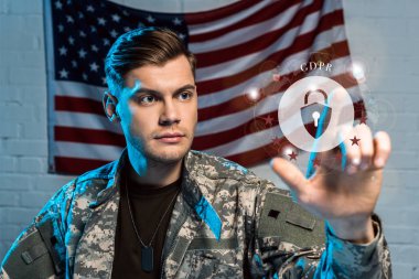 yakışıklı askerin seçici odak Amerikan bayrağı yakınındaki asma kilit parmak ile işaret 