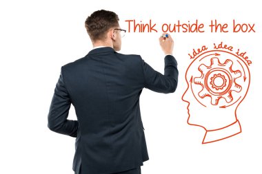 back view of businessman holding marker pen near think outside the box lettering on white  clipart