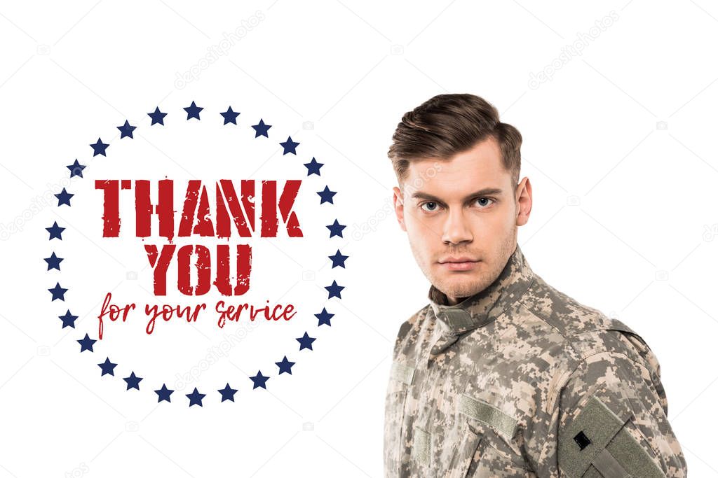 serious and handsome soldier in uniform looking at camera near thank you for your service lettering on white 