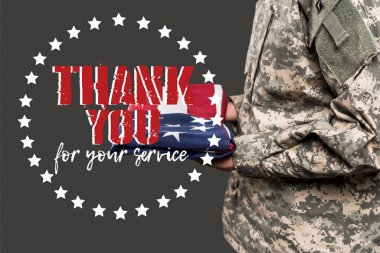 cropped view of man in military uniform holding flag of america near thank you for your service lettering on grey  clipart