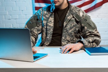 ofiste dizüstü bilgisayar kullanarak üniformalı askerin kırpılmış görünümü 