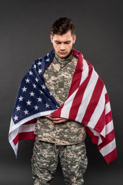 gri izole Amerikan bayrağı ile askeri üniformalı üzgün adam 