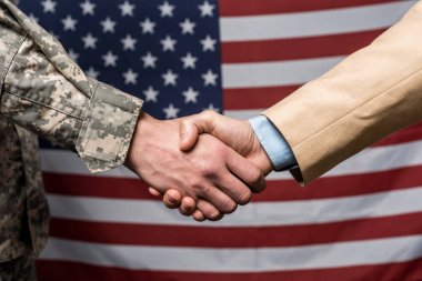 seçici odak askeri erkekler Amerikan bayrağı yakınında el sıkışma 