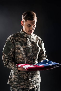 askeri üniformalı adam siyah amerikan bayrağı bakarak 