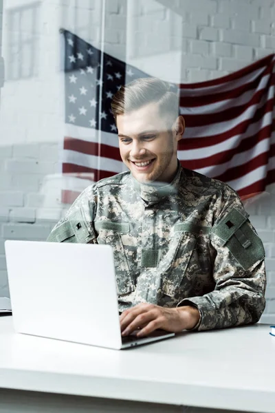 快乐的年轻士兵在迷彩服使用笔记本电脑在办公室 — 图库照片