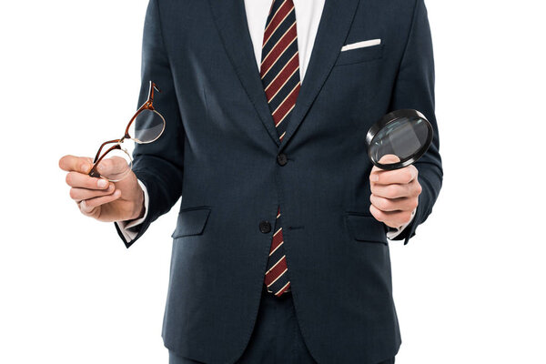 cropped view of businessman holding glasses and magnifying glass isolated on white 