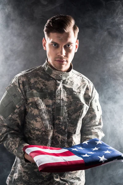 Όμορφος Άνθρωπος Στρατιωτική Στολή Κρατώντας Αμερικάνικη Σημαία Μαύρο Καπνό — Φωτογραφία Αρχείου