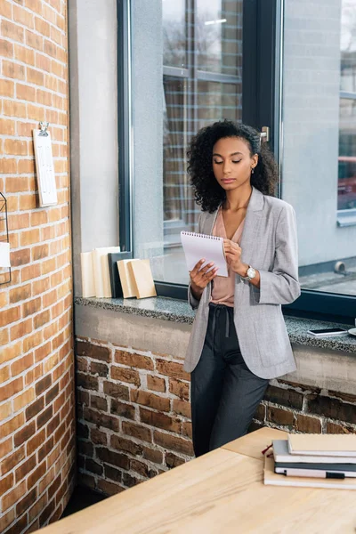 Afrikanisch Amerikanische Gelegenheitsunternehmerin Schreibt Notizblock Loft Büro — Stockfoto