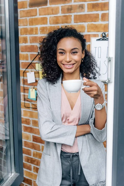 Sonriente Afroamericana Casual Mujer Negocios Con Taza Café Mirando Través — Foto de Stock