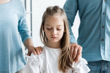 cropped view of parents putting hands on shoulders of upset daughter  clipart