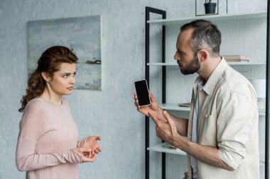 kadın yakınında boş ekran ile akıllı telefon parmak ile işaret üzgün adam