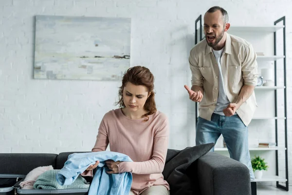 Bonito Homem Gestos Gritando Enquanto Olhando Para Mulher Embalagem Roupas — Fotografia de Stock