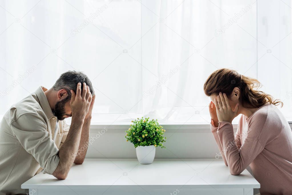 upset man and woman sitting at home after quarrel 