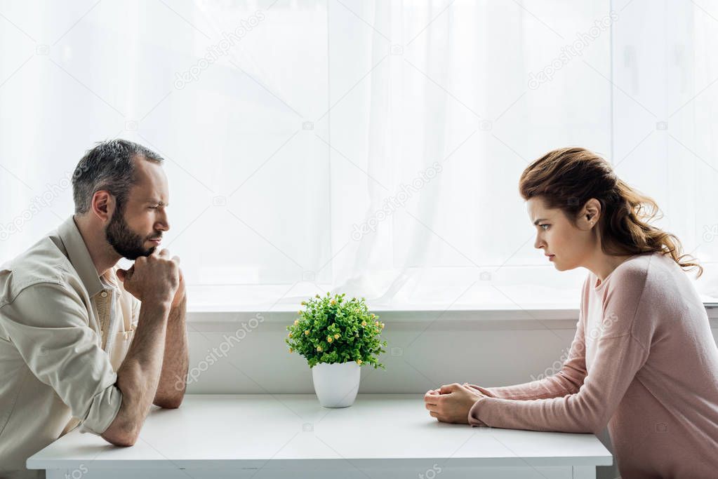 handsome bearded man and upset and attractive woman after quarreling at home 
