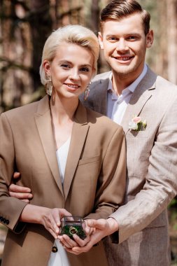 ormanda kucaklayan alyansile romantik şık çift