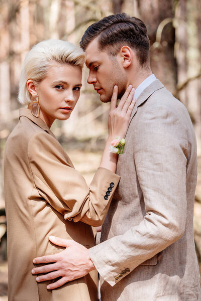 Side view of handsome man and woman in forest  