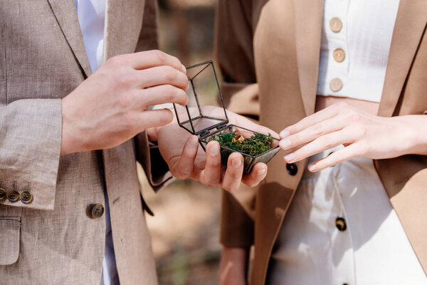 Cropped view of man proposing to woman in forest