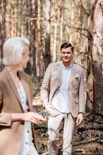 Smiling Bridegroom Standing Hand Pocket Looking Bride Forest — Stock Photo, Image