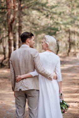 sadece evli çift kucaklayan ve ormanda birbirlerine bakarak geri görünümü
