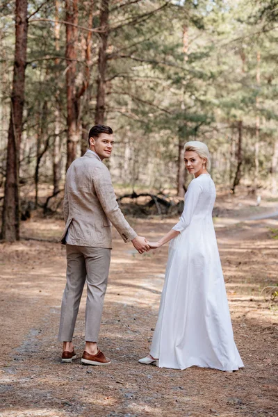 Vista Completa Sonriente Pareja Recién Casados Tomados Mano Bosque —  Fotos de Stock