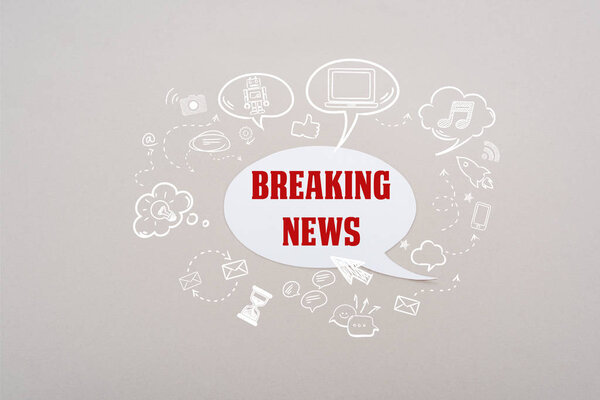 white speech bubble with red breaking news lettering and social media illustration on grey background