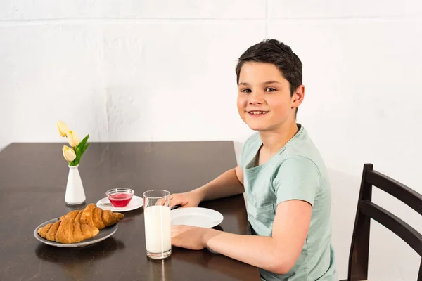 Smiling Boy Sitting Table Croissants Syrup Glass Milk — Stock Photo, Image