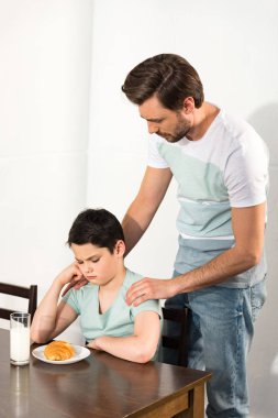 kahvaltı sırasında masada baba ve üzgün oğlu