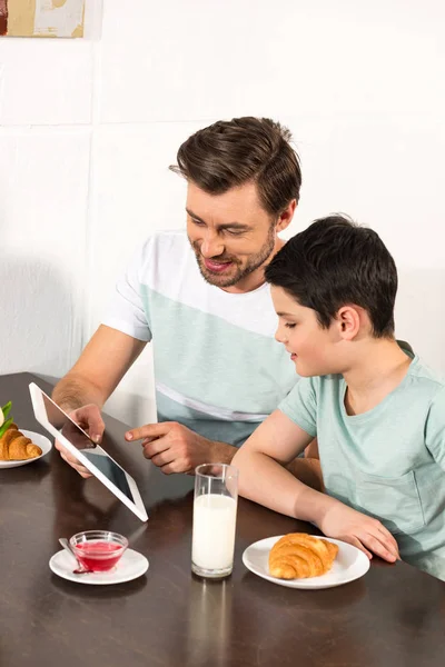 Kahvaltı Sırasında Dijital Tablet Kullanarak Gülümseyen Baba Oğul — Stok fotoğraf