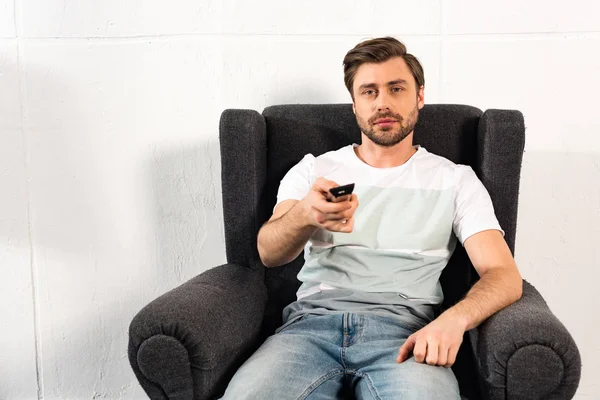 Man Jeans Sitting Armchair Holding Remote Controller — Stock Photo, Image