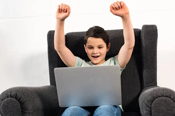 Aufgeregter Junge Jeans Sitzt Sessel Und Benutzt Laptop — Stockfoto