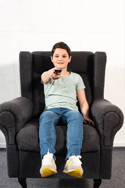 Menino Jeans Sentado Poltrona Segurando Controle Remoto — Fotografia de Stock