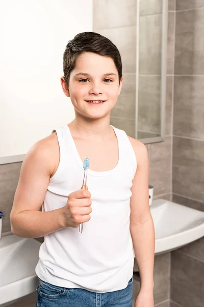 Niño Sonriente Sosteniendo Cepillo Dientes Mirando Cámara Baño —  Fotos de Stock